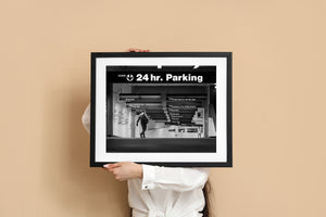 Black and white urban scene with cascading parking signs