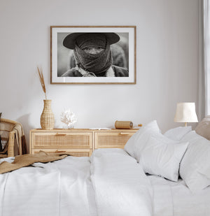 Direct gaze visible above a wrapped fabric face covering