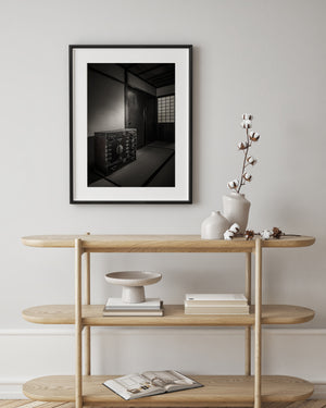 Restrained Japanese room with a detailed storage chest and soft light through a gridded screen.