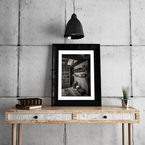 Dark timber beams cross above shelves of household objects in Matsue, Japan.