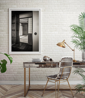 Black and white Japanese interior with layered doorframes, ceiling beams and tatami borders.