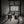 Black and white still life of Japanese carrying chests beneath a gridded paper window.