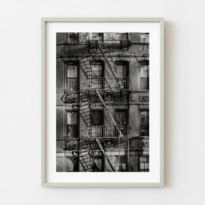 Black and white New York City brick facade with fire escapes