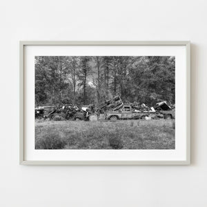 Black and white photograph of scrap cars in Northern Ontario