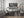 Scrap car wall with damaged pickup truck wheels and metal debris