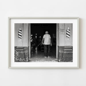Older man standing in Cuba barber shop doorway black and white