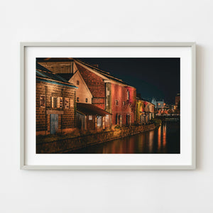Historic red brick warehouses beside Otaru Canal at night