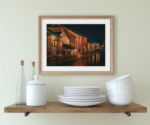 Dark canal water reflecting red brick buildings and streetlights