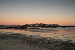 Warm sunset above coastal homes and tidal flats in Maine