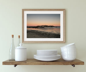 Quiet Maine beach reflecting peach evening light