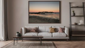 Coastal community beneath a soft pink and blue sky