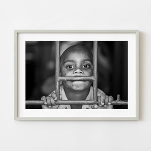 Black and white portrait of a boy at a train window in India