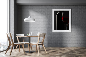 Dark wine bottle behind a glowing red wine glass