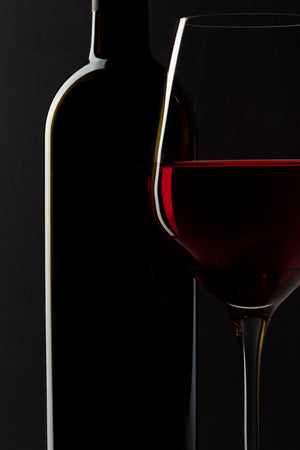 Ruby red wine line crossing a dark studio still life