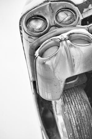 Old classic car with four round lights and weathered chrome