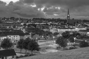 Rosemount rooftops and church spire illuminated at dusk
