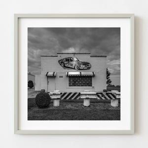 Black and white Route 66 car shop with painted sports car mural