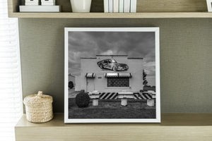 Americana roadside scene with faded car mural and dramatic sky