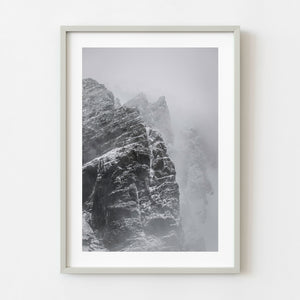 Rugged Antarctic mountain rising through blowing snow