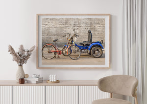 Rusty bicycle frame and blue three wheeled cart