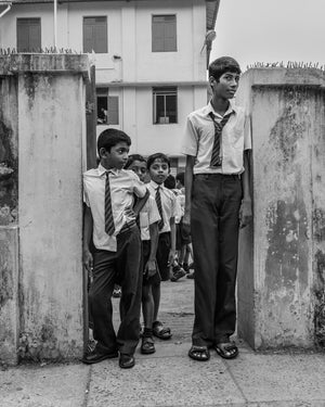 Indian schoolboys wearing uniforms at a school entrance