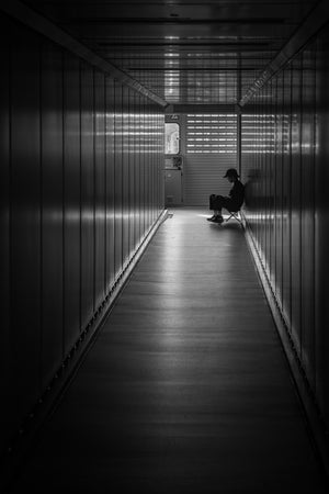 Seated figure at the end of a dark Hanoi airport corridor