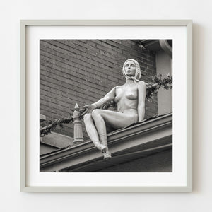 Seated rooftop mannequin with dangling legs in Toronto