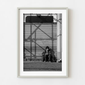 Black and white street portrait of seated woman in Naples Italy