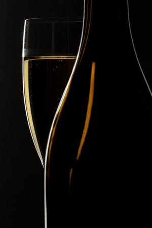 Golden bubbles rising through sparkling wine against black