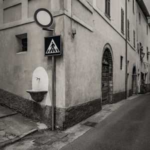 Old town street corner in Spoleto Italy with fountain and arched doors