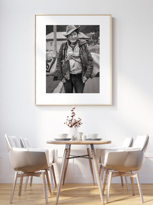 Weathered man in hat standing beside a pack animal