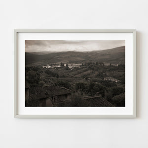 Monochrome Tuscany village surrounded by rolling countryside at dusk