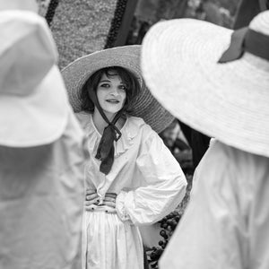 Woman wearing a wide woven hat during an Italian village parade