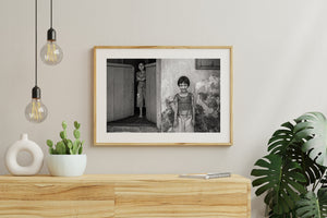 Black and white photograph of children beside wooden doors in India