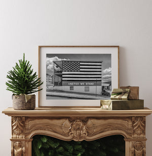 Weathered brick building with painted stars stripes and United We Stand