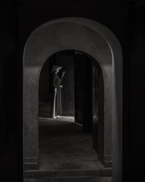 Vietnamese woman in ao dai and conical hat inside Hue mausoleum