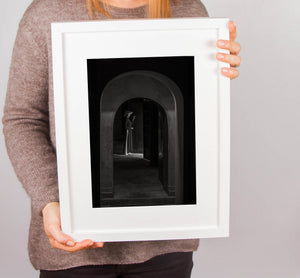 Woman illuminated by natural light inside historic Hue architecture