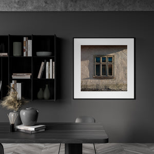 Rustic wooden window with peeling frames and dark glass
