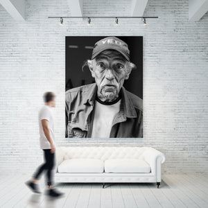 Vertical black and white portrait of an older man in a worn jacket
