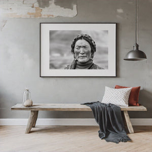 Tibetan woman facing the camera with braided hair and textured skin