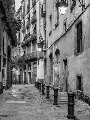 Historic Barcelona street with stone pavement and iron bollards