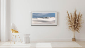 Rolling white desert dunes with distant dark green scrub