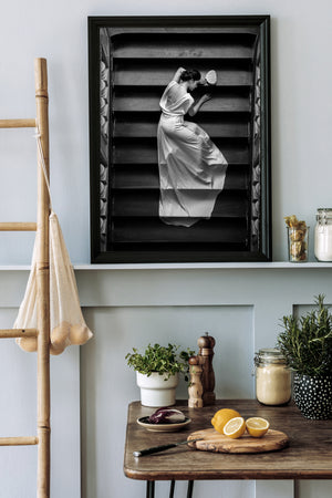 Vertical black and white portrait framed by ornate staircase details