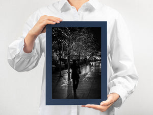Monochrome urban photograph of a solitary woman at night