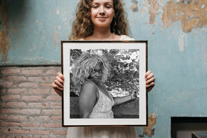 Manhattan woman in patterned dress posed before a leafy background