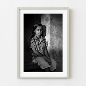 Young Indian girl sitting in a window in black and white