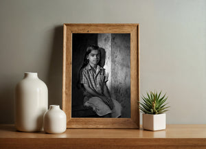Girl seated on window sill with strong light and shadow