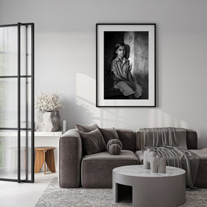 Black and white portrait of Indian girl beside textured wall