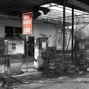 Weathered fuel pumps and an exposed canopy at an abandoned Southern Georgia station.