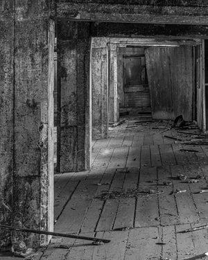 Concrete columns recede through a derelict factory above damaged wooden floorboards